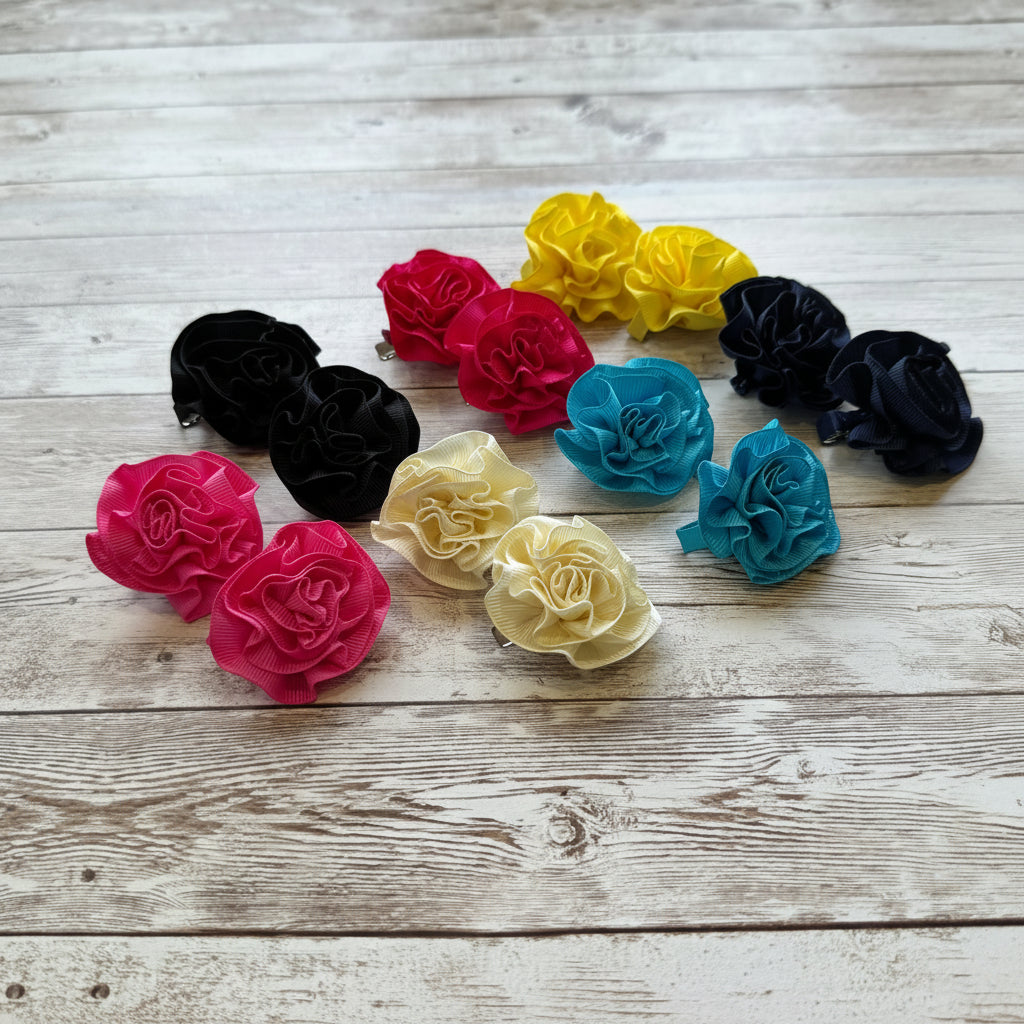 Colorful carnation-style hair clips on a wooden surface